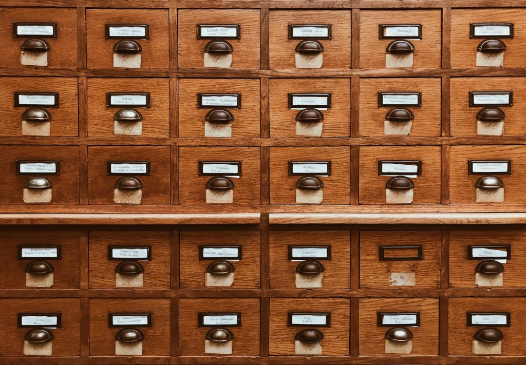 Image shows the exterior of a vintage wooden library card catalogue shelf